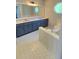 Full bathroom features double vanity, jetted tub, and large mirror and tile flooring at 4905 Puritan Dr, Sugar Hill, GA 30518