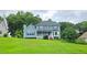 Charming two-story blue home featuring a manicured lawn, inviting porch, and classic architectural details at 4905 Puritan Dr, Sugar Hill, GA 30518