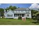 Charming two-story home with light blue siding, inviting front porch, and well-maintained lawn at 4905 Puritan Dr, Sugar Hill, GA 30518