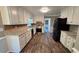 Modern kitchen with white cabinetry, stainless steel appliances, and dark hardwood floors at 4905 Puritan Dr, Sugar Hill, GA 30518