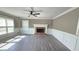 Cozy living room featuring a traditional brick fireplace and ample natural light from large windows at 4905 Puritan Dr, Sugar Hill, GA 30518