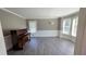 Bright living room with hardwood floors, bay windows, and crown molding, featuring a vintage piano at 4905 Puritan Dr, Sugar Hill, GA 30518