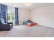 Bright bedroom featuring carpet, a window with patterned curtains, and a comfortable blue armchair at 1048 Shadow Glen Dr, Fairburn, GA 30213