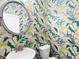 Stylish powder room featuring a round mirror, white sink and toilet, and fun peacock wallpaper at 1048 Shadow Glen Dr, Fairburn, GA 30213