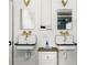 Bathroom featuring dual sinks with gold fixtures, mirrors, and tiled walls at 10975 Hutcheson Ferry Rd, Chattahoochee Hills, GA 30268