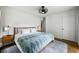 Bright bedroom with a wood-frame bed, modern ceiling fan, and hardwood floors at 10975 Hutcheson Ferry Rd, Chattahoochee Hills, GA 30268