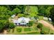 An aerial view features a well-maintained home with a pool, patio, and cultivated land at 10975 Hutcheson Ferry Rd, Chattahoochee Hills, GA 30268