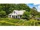 Lovely farmhouse showcasing a large yard and beautiful landscaping at 10975 Hutcheson Ferry Rd, Chattahoochee Hills, GA 30268