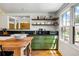 Sunlit kitchen showcases olive-green cabinetry, a butcher-block island, and charming open shelving at 10975 Hutcheson Ferry Rd, Chattahoochee Hills, GA 30268