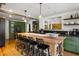 Bright kitchen features an oversized wood island, stainless appliances, and olive-green cabinets at 10975 Hutcheson Ferry Rd, Chattahoochee Hills, GA 30268