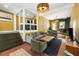 Inviting living area with brick floors, a cozy fireplace, comfortable seating, and natural light at 10975 Hutcheson Ferry Rd, Chattahoochee Hills, GA 30268