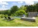 Backyard featuring a pristine in-ground pool and a stone-trimmed hot tub and lounge chairs at 10975 Hutcheson Ferry Rd, Chattahoochee Hills, GA 30268