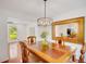 Bright dining room features a modern chandelier, wooden table, and view to the greenery outside at 1380 Heritage Glen Dr, Marietta, GA 30068