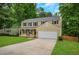 Traditional home features a two-car garage, lush greenery, and welcoming curb appeal at 1380 Heritage Glen Dr, Marietta, GA 30068