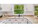 Updated kitchen features granite countertops, stainless sink, and a window overlooking the backyard at 1380 Heritage Glen Dr, Marietta, GA 30068