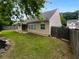 Spacious backyard with a well-manicured lawn, privacy fence, stone detail, and a covered patio at 2586 Gristhaven Ln, Buford, GA 30519