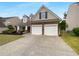 Home's exterior showcasing a two-car garage, stone accents, and a well-maintained lawn at 2586 Gristhaven Ln, Buford, GA 30519