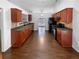 Efficient kitchen layout with wood cabinets, black appliances, and seamless access to the dining area at 2586 Gristhaven Ln, Buford, GA 30519