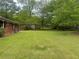 Spacious backyard view showing lush green grass, mature trees, and a partial view of the home's exterior at 3731 Wisteria Se Ln, Smyrna, GA 30082