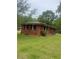 Expansive backyard showcasing the home's brick exterior, with black shutters, and lush green lawn at 3731 Wisteria Se Ln, Smyrna, GA 30082