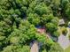 Aerial view of a home nestled in the forest, surrounded by dense trees and lush greenery at 3809 Cotswold Sw Dr, Lilburn, GA 30047