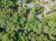 Overhead view of a home nestled among mature trees near a winding river surrounded by lush greenery at 3809 Cotswold Sw Dr, Lilburn, GA 30047