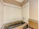 Bathroom with beige tile walls and floors, a shower-tub combination, and toilet at 3809 Cotswold Sw Dr, Lilburn, GA 30047