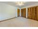 Spacious bedroom with neutral carpet, ceiling fan and two closets with wooden doors at 3809 Cotswold Sw Dr, Lilburn, GA 30047