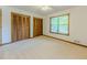 Bright bedroom featuring neutral carpet, white walls, two closets with wood-slatted doors, and a window at 3809 Cotswold Sw Dr, Lilburn, GA 30047