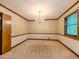 Formal dining room with elegant chandelier, soft carpet, and detailed wall trim at 3809 Cotswold Sw Dr, Lilburn, GA 30047