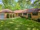 Charming single-story brick home with a manicured lawn and lush landscaping at 3809 Cotswold Sw Dr, Lilburn, GA 30047