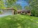 Charming single-story brick home with a manicured lawn, attached garage and lush landscaping at 3809 Cotswold Sw Dr, Lilburn, GA 30047