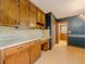 Functional kitchen area with wood cabinets, desk space, and access to additional storage and dining areas at 3809 Cotswold Sw Dr, Lilburn, GA 30047