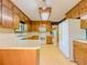 Charming kitchen featuring warm wood cabinets, white appliances, and a spacious countertop, ideal for Gathering meals at 3809 Cotswold Sw Dr, Lilburn, GA 30047