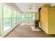 Bright sunroom featuring large windows, brick walls, ceiling fan, and vintage wood-burning stove at 3809 Cotswold Sw Dr, Lilburn, GA 30047
