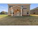 Brick home's backyard with covered porch, ceiling fan, and a spacious lawn at 124 Dalston Cv, Stockbridge, GA 30281
