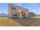 Brick home's backyard featuring a covered porch, spacious lawn and blue skies at 124 Dalston Cv, Stockbridge, GA 30281