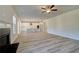 Open-concept living room with wood-look floors seamlessly connecting to a modern kitchen and fireplace at 124 Dalston Cv, Stockbridge, GA 30281