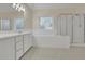 Bright bathroom with dual sinks, a soaking tub, and a glass-enclosed shower at 1558 Ember Oaks Cir, Powder Springs, GA 30127