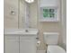 Clean, compact bathroom with a white vanity, a toilet, and a window above the sink at 1558 Ember Oaks Cir, Powder Springs, GA 30127