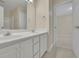 Bright bathroom featuring double sinks, white cabinetry and a view into the bedroom at 1558 Ember Oaks Cir, Powder Springs, GA 30127