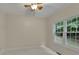 Cozy bedroom with a ceiling fan, neutral paint, and a large window overlooking greenery at 1558 Ember Oaks Cir, Powder Springs, GA 30127