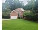 Well-maintained two-story brick home with a large front lawn and attached two car garage at 1558 Ember Oaks Cir, Powder Springs, GA 30127