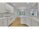 Bright, all-white kitchen with modern appliances, granite countertops, and hardwood floors at 1558 Ember Oaks Cir, Powder Springs, GA 30127