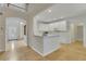 Open-concept living area featuring hardwood floors, white cabinets, and a kitchen island at 1558 Ember Oaks Cir, Powder Springs, GA 30127