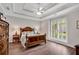 Bedroom with hardwood floors, tray ceilings, and a large window with shutters at 753 Cambron Commons Trce, Suwanee, GA 30024