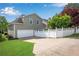 Charming house exterior with a garage, green lawn, and a white picket fence at 753 Cambron Commons Trce, Suwanee, GA 30024
