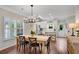 Bright kitchen and dining area with hardwood floors, island, modern appliances, and beautiful shuttered windows at 753 Cambron Commons Trce, Suwanee, GA 30024