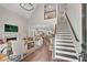 Open-concept living room with a fireplace, high ceilings, and stairs to the second floor at 753 Cambron Commons Trce, Suwanee, GA 30024