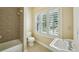 Bright bathroom featuring tiled shower-tub, toilet, sink, and plantation shutters for natural light at 963 Manor Parc Dr, Decatur, GA 30033